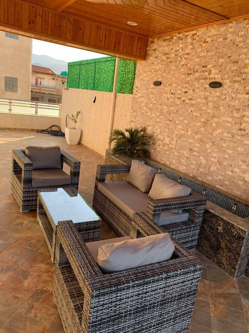  un canapé deux places, deux fauteuils individuels et une table basse avec un plateau en verre trempé